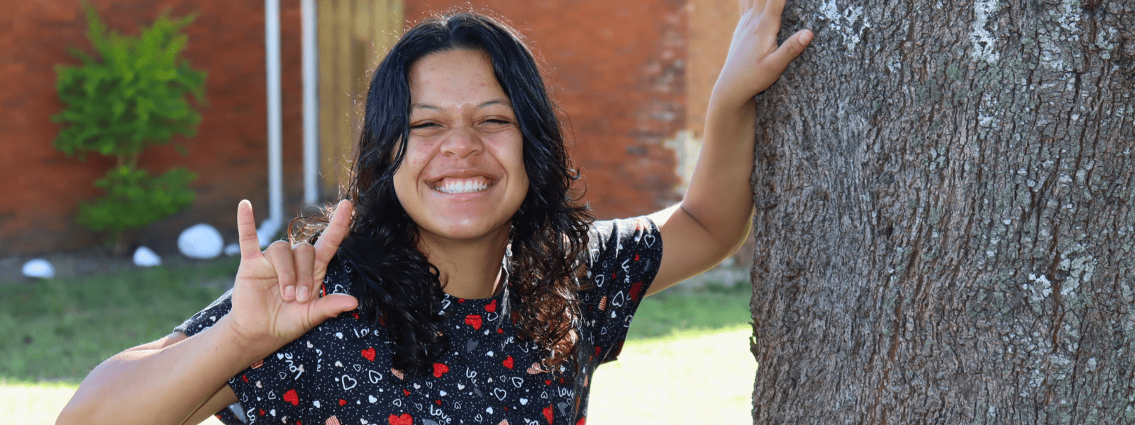 Beatriz* saying "I love you" in sign language.